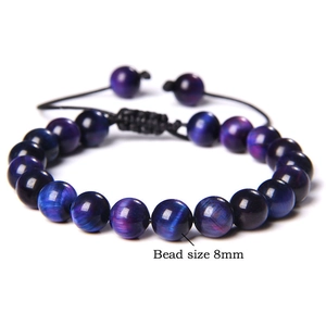 Detailed view of 8mm tiger eye stone beads with adjustable braided cord on white background