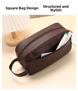 Detail of dark brown leather texture and dual zipper design on a waterproof wash bag