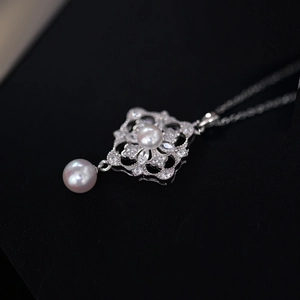 Elegant silver rhodium necklace with flower zircon pendant and white pearls on black background