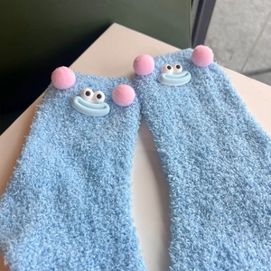 Cute light blue coral fleece socks with pink pom-poms and cartoon big eye face