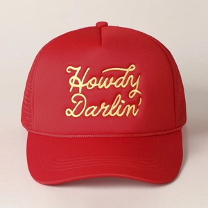 Dettaglio del cappello trucker rosso in rete con ricamo giallo Howdy Darlin’ sul fronte