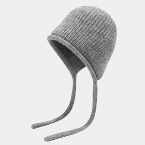 Macro shot of grey knitted beanie with ribbed texture and hanging tassels