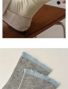 Detailed view of ribbed knit cotton socks with contrasting grey and blue cuffs