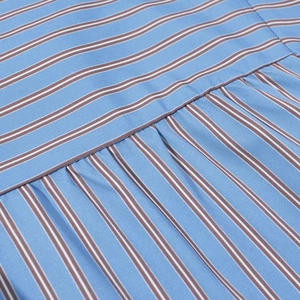 Detailed macro view of the blue and white striped cotton fabric texture with brown accents
