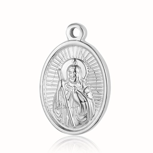 Macro detail of silver vintage saint pendant with embossed religious figure on stainless steel