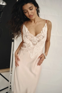 Close-up of pink satin nightdress with white lace patchwork and fine silk texture