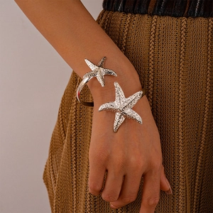 Detail of silver starfish arm cuff featuring realistic textured sea star design on wrist