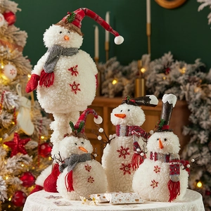 Set di quattro pupazzi di neve in peluche con sciarpe e cappelli invernali