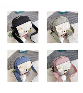 Quatre petits sacs bandoulière en toile en noir, vert, bleu et rose avec des écussons mignons