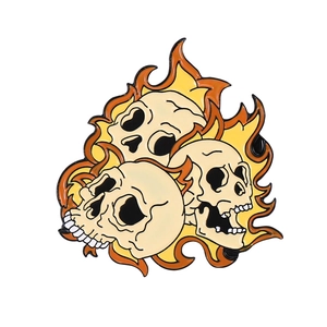 Detailed close-up of a punk gothic skull flame alloy brooch with vibrant orange details