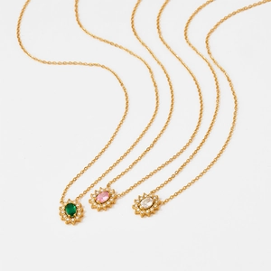 Trois colliers tournesol en acier doré avec zircons verts, roses et transparents