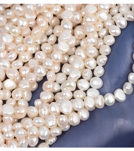 Macro shot of 9-10mm baroque freshwater pearls with high luster on blue silk
