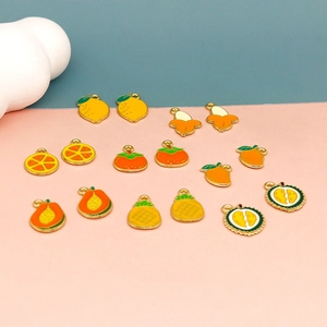 Flat lay of colorful alloy fruit charms including lemon, orange and pineapple