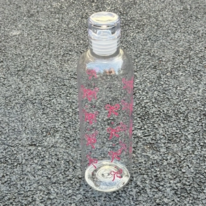 Macro detail of 250ml scale markings and pink bow pattern on the clear plastic bottle
