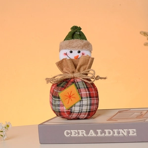 Close-up of snowman drawstring candy bag with red and green plaid fabric on a book
