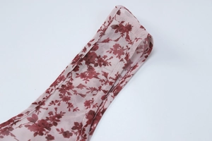 Detailaufnahme von durchscheinendem Blumenmusterstoff mit hochwertig gesäumten Kanten am Kleid