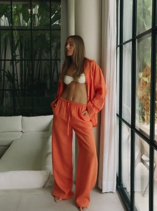 Women's orange linen-style lounge set with loose shirt and wide-leg trousers