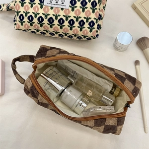 Detailed view of tulip floral and checkerboard corduroy makeup bags with top handles