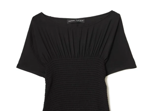 Détail d'un haut noir à manches courtes avec design froncé élastique et tissu fluide
