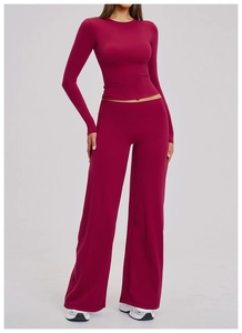 Detailed close-up of dark red high-elasticity yoga set with long sleeve top and wide-leg pants