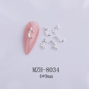 Detailed view of silver bow nail art charms size 4x9mm on a pink manicure display
