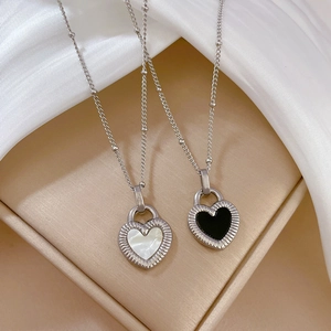 Detail of silver heart pendants with white shell and black onyx on beaded chain necklaces