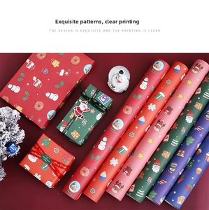 Flat lay of assorted Christmas wrapping paper rolls with festive motifs and gift ribbons