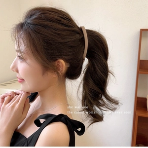 Matte brown banana clip shown on a woman hairstyle in a minimalist home setting