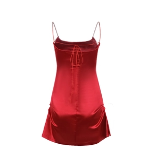 Detail shot of a red satin slip dress featuring cross-back tie straps and glossy finish