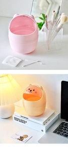 Detailed view of mini bear-shaped desktop trash cans in pink and yellow for home office use