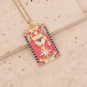 Détail du pendentif Tarot du Diable avec émail rose et cristaux colorés sur chaîne dorée