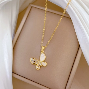 Detail of gold butterfly necklace with shell inlay and cubic zirconia on silk