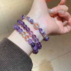 Detailed close-up of triple-layered natural amethyst bead bracelet with silver accents