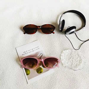 Retro oval sunglasses in tortoiseshell and pink frames with minimalist lifestyle props