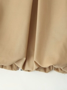 Gros plan du tissu kaki avec couture de l'ourlet et détail du zip argenté