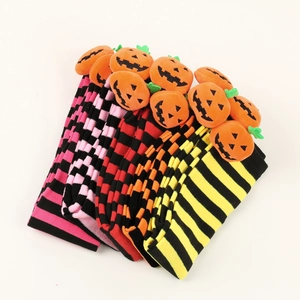 Detail of colorful Halloween striped thigh high socks with 3D plush pumpkin decorations
