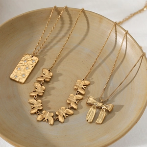 Gold stainless steel bow necklace set with square pendant and zircons in a ceramic bowl