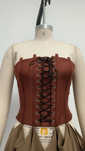 Détail du haut corset bordeaux à lacets avec texture tissée et œillets métalliques
