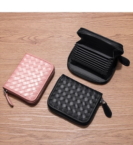 Detail of woven leather card holders showing accordion slots and zip closure design
