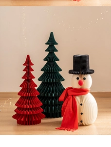 Detailed view of honeycomb paper Christmas trees and snowman with festive light background