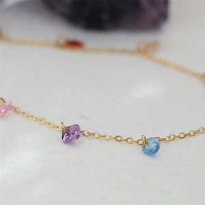 Macro shot of colorful zircon stones on an 18K gold-plated titanium steel bracelet