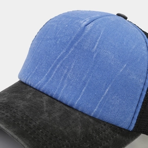 Detail showing washed distressed canvas fabric and white bleached stripes on trucker hat