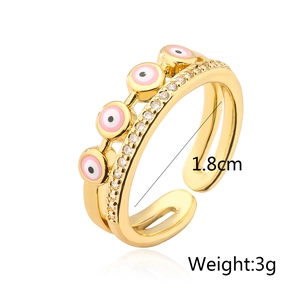 Detailed view of gold evil eye ring with pink enamel charms and white cubic zirconia
