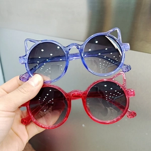 Detail view of cute cat-ear shaped sunglasses for kids with blue and red plastic frames