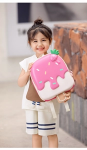 Close-up of pink ice cream shaped kids backpack with strawberry detail on a little girl