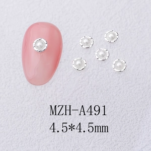 Macro detail of 4.5mm floral pearl nail art charms with silver alloy flower bezels