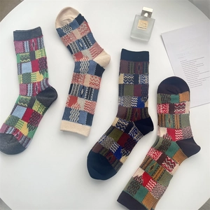 Flat lay of vintage colorful plaid cotton socks with geometric patchwork patterns on a table