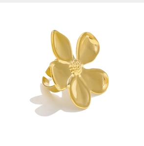Detail shot of a polished golden 3D flower open ring featuring a textured petal center