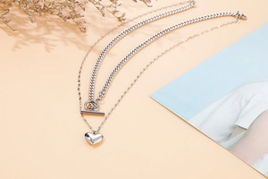 Detailed view of silver double-layer titanium necklace with OT buckle and heart pendant
