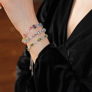 Detailed view of three colorful zircon flower bracelets on a black velvet sleeve